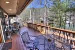 Large back deck with gas grill and walkway to boathouse deck